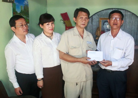Ông Trần Văn Thành, Chủ tịch Công đoàn SAWACO (bìa phải), trao tiền hỗ trợ cho công nhân bệnh hiểm nghèo