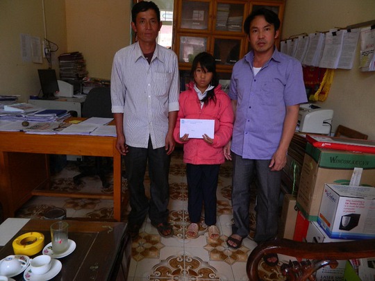 Ông Nguyễn Đức Mạnh, Chủ tịch LĐLĐ huyện Mù Cang Chải, trao tiền của bạn đọc đến em Hảng Thị Dùa