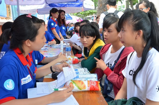 Sinh viên tình nguyện của TP HCM hỗ trợ thí sinh tìm địa điểm thi trong sáng 29-6 Ảnh: TẤN THẠNH
