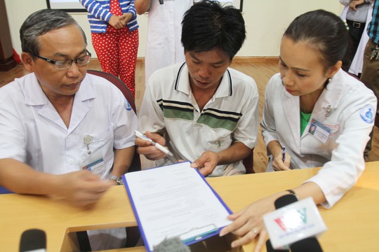 Trong khi đó, tại Hội trường bệnh viện, BS Nguyễn Thanh Hùng (trái), giám đốc BV, đã trao sổ tiết kiệm 50 triệu đồng và hơn 15 triệu tiền mặt do các nhà hảo tâm ủng hộ cho cha cháu bé là anh Dương Minh Tiền