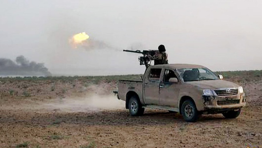 Một tay súng IS bắn về phía quân đội chính phủ. Ảnh: Islamic State militants