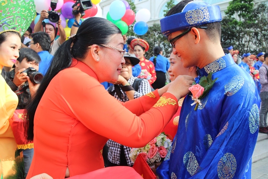 Bà Nguyễn Thị Bích Thủy, Phó Chủ tịch LĐLĐ TP HCM, trao huy hiệu Thành phố cho các cô dâu, chú rẻ