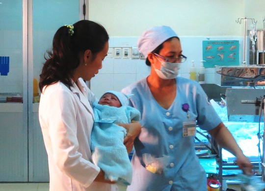 Bé Phát tỉnh giấc nhoẻn miệng cười với BS Phạm Thị Thanh Tâm, trưởng khoa Hồi sức sơ sinh khi được bồng lên để chuẩn bị giao cho mẹ
