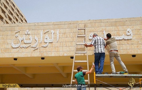 Refurbishment: Workmen use sledgehammers to remove carvings on the side of the building and replace them with simplistic Arabic writing