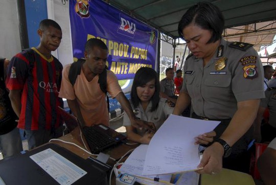 Thân nhân hành khách cung cấp thông tin cho cảnh sát tại sân bay Sentani, gần Jayapura, tỉnh Papua hôm 17-8. Ảnh: Reuters