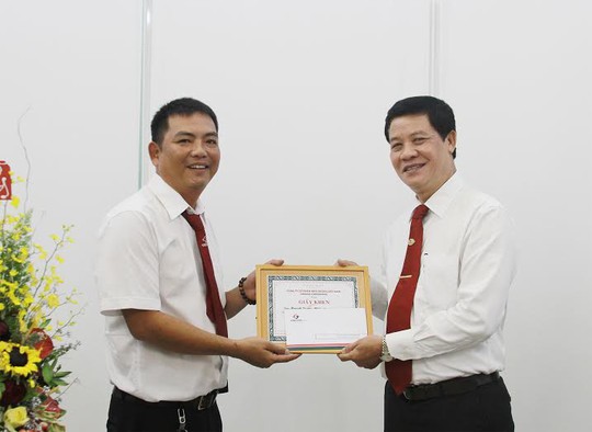 Ông Trương Đình Quý (bìa phải), Phó Tổng giám đốc Vinasun Corp, trao giấy khen cho lái xe Huỳnh Quang Minh