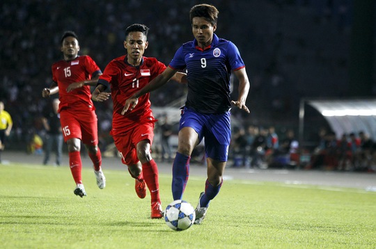 Khuon Boravy (Campuchia) đi bóng trước các hậu vệ Singapore