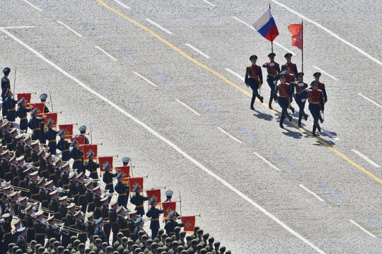 Quốc kỳ Nga và lá cờ chiến thắng được rước qua quảng trường. Ảnh: Reuters