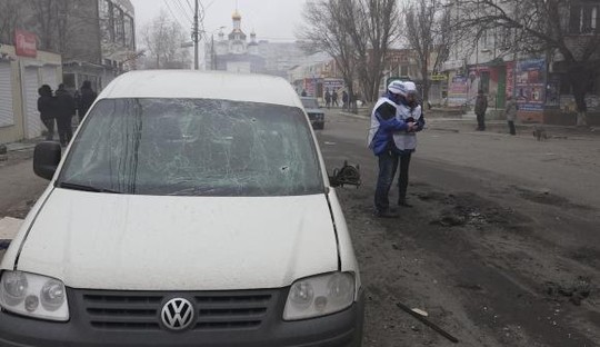 Các chuyên gia của Tổ chức An Nninh và Hợp tác châu Âu (OSCE) đang xem xét các mảnh đạn pháo sau vụ tấn công ở Mariupol, miền Đông Ukraine hôm 24-1-2015. Ảnh: Reuters