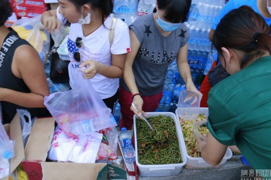 Tình nguyện viên cung cấp thức ăn cho người bị nạn ở Thiên Tân.