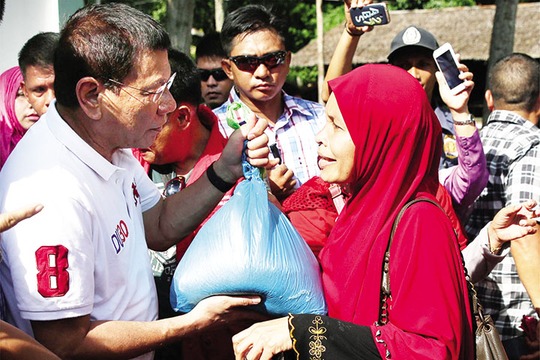 Tổng thống Duterte phát hàng viện trợ cho người dân trong chuyến thăm tỉnh Basilan hồi tháng 7. Ảnh: PPD
