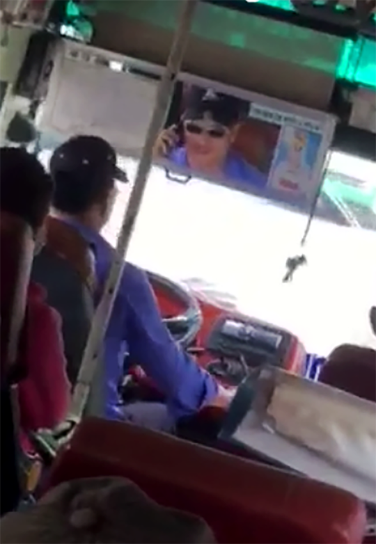 
Tài xế xe buýt vừa nghe điện thoại vừa thả tay khỏi vô lăng - Ảnh cắt từ clip.
