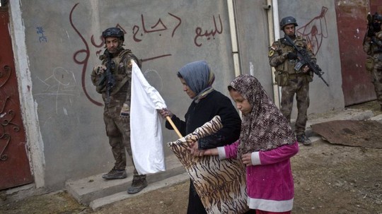 Người dân mang cờ trắng trong khi quân đội Iraq tìm kiếm thánh viên IS ở ngoại ô Mosul. Ảnh: AP