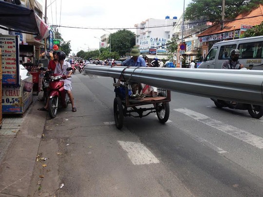 
Chiếc xe ba gác chở cuộn tôn dài hơn 10 m di chuyển trên đường Phan Văn Trị (quận Gò Vấp, TP HCM) Ảnh: GIA MINH
