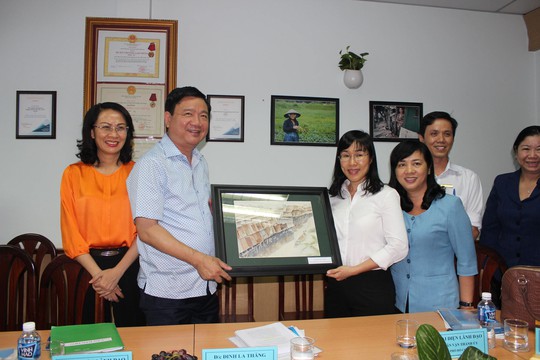 Đại diện Quỹ Trợ vốn CEP (bìa phải) tặng quà lưu niệm cho lãnh đạo Thành ủy và UBND TP HCM