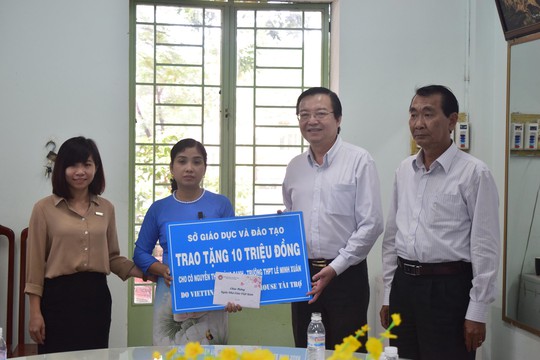 
Ông Lê Hồng Sơn (thứ hai từ phải qua), Giám đốc Sở GD-ĐT TP HCM, tặng quà cho cô Nguyễn Thị Hoàng Oanh
