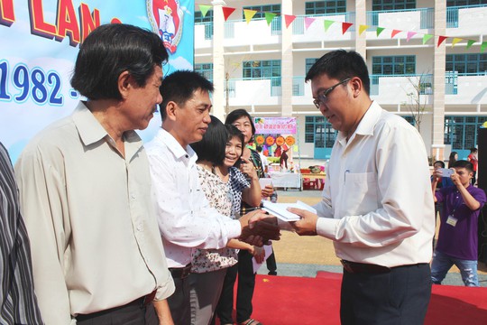 Ông Nguyễn Vũ Hạnh Phúc - Phó Chủ tịch LĐLĐ quận 8, TP HCM - trao tiền hỗ trợ cho giáo viên khó khăn