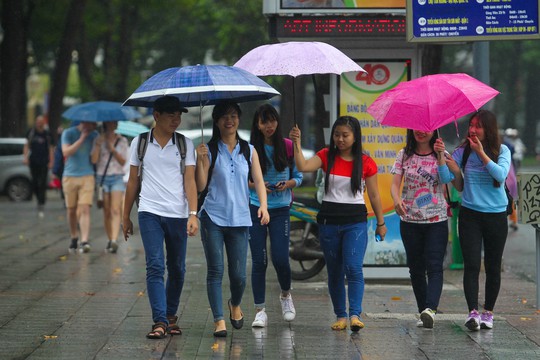 
Nhóm khách mang theo mỗi người một chiếc dù, chụp hình trước nhà thờ Đức Bà
