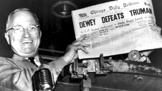 
Tổng thống Harry Truman tươi cười cầm tờ báo Chicago Tribune in dòng tít lớn “Dewey đánh bại Truman” Ảnh: UPI
