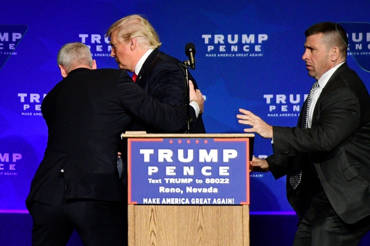 Tỉ phú Donald Trump được nhân viên mật vụ đưa đi khi đang phát biểu tại TP Reno hôm 5-11Ảnh: Reuters