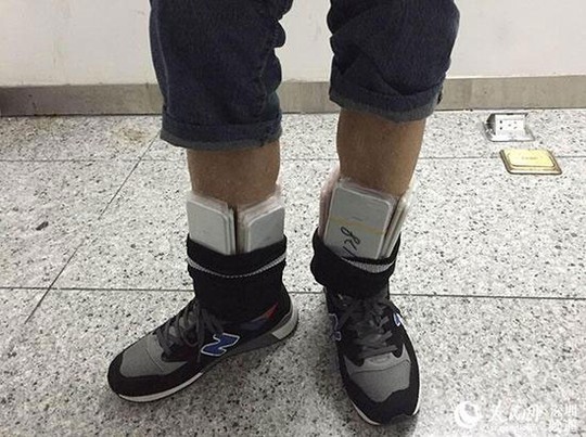 
Số iPhone lậu được quấn quanh bụng và chân. Ảnh: People.cn, Guangzhou Daily
