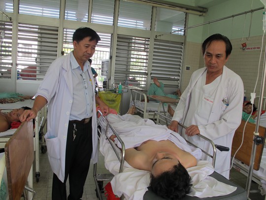 
Bác sĩ Vũ (phải) và bác sĩ Trí thăm hỏi bệnh nhân sau ca phẫu thuật
