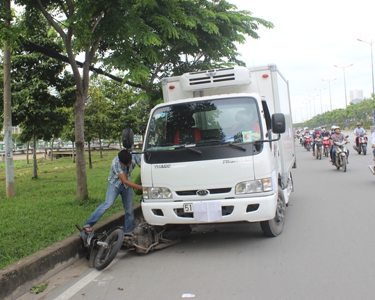 Tại hiện trường, xe máy bị ép sát vào lề đường, xe tải đã che biển số