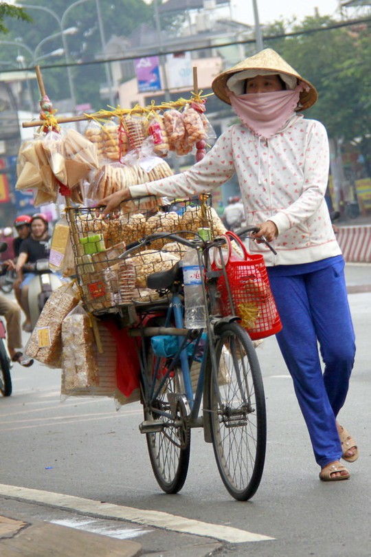 
Chị bán bánh dạo với xe bán các loại bánh bình dân, trong đó có bánh chao - Ảnh: BẢO KHÔI
