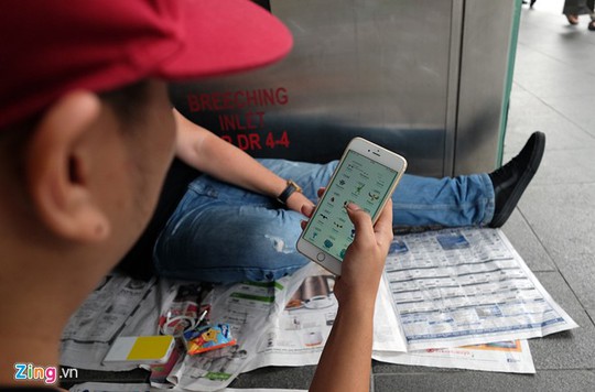 
Một người chơi Pokemon Go trong lúc chờ đợi. Điện thoại, sách báo... là những thú vui ít ỏi giúp những người xếp hàng ở đây giết thời gian.
