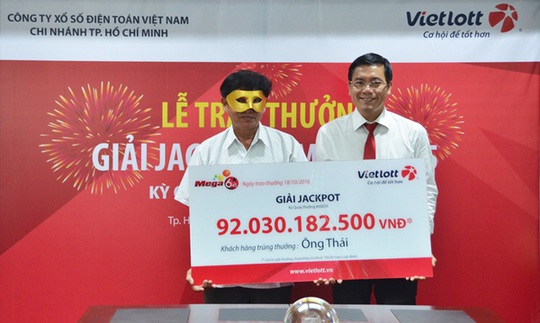 Một người trúng giải xổ số của Vietlott đeo mặt nạ nhận thưởng.