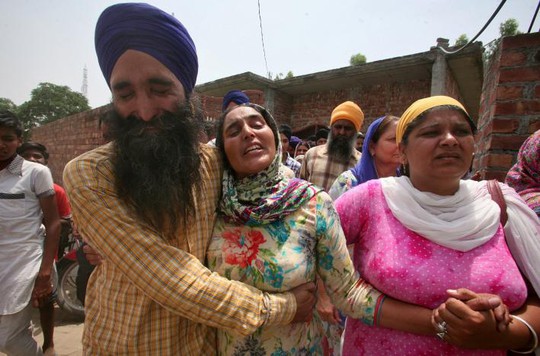 Vợ của binh sĩ Ấn Độ Paramjit Singh (giữa) gần như ngất lịm khi được thông báo chồng cô bị quân đội Pakistan giết chết. Ảnh: REUTERS