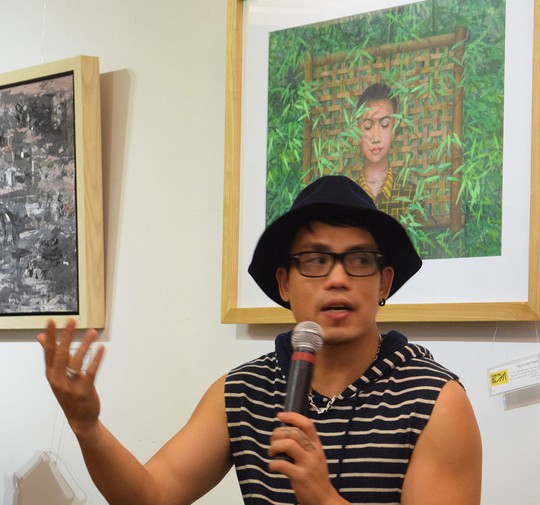 Giám tuyển Như Huy đang giới thiệu tại một cuộc triển lãm tranh
