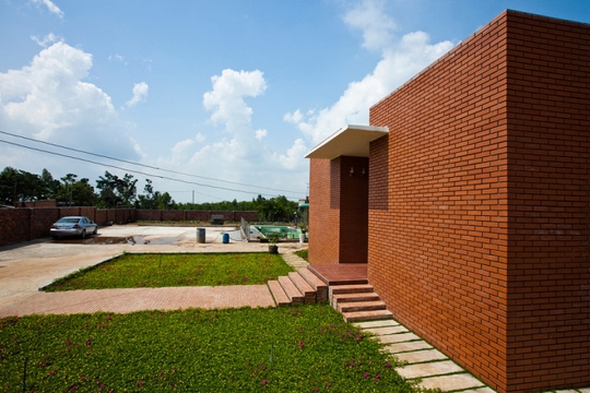 
KTS Bùi Thế Long đưa ra ý tưởng thiết kế nhà giống như khối gạch đỏ nổi bật giữa màu xanh cây cỏ vào mùa mưa.

