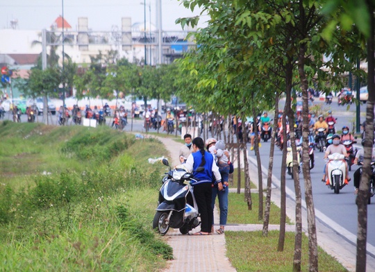 
Một gia đình phải tấp vào lề đường Phạm Văn Đồng ngồi nghỉ do đi quãng đường xa
