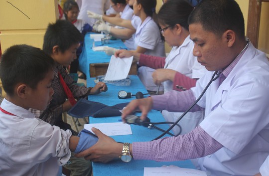 Các y - bác sĩ khám sàng lọc cho học sinh ở xã Hạnh Dịch vào sáng 22-2. Ảnh: HUỆ CẢNH