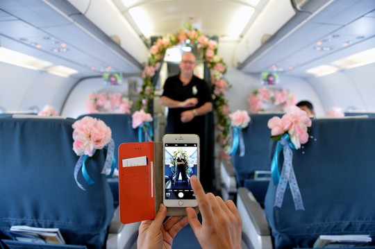 
Một hành khách đến từ châu Âu thích thú với hoa trang trí trên máy bay.
