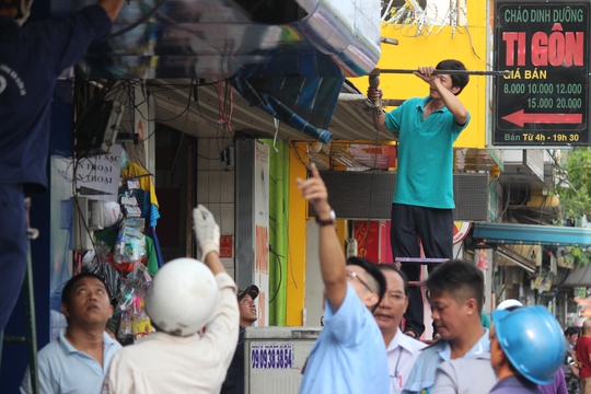 Dân tự nguyện tháo bỏ phần biển hiệu lấn chiếm vỉa hè.