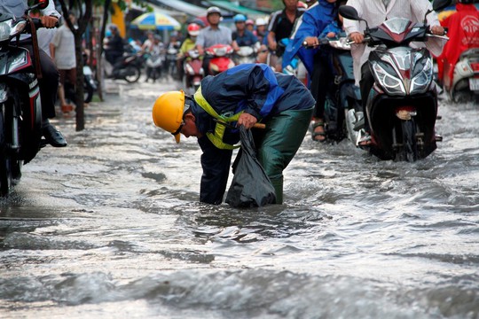 Người dân TP HCM bì bõm sau cơn mưa lớn - Ảnh 2.