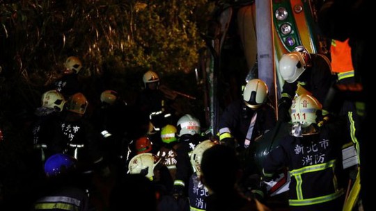 
Lực lượng cứu hộ cố gắng giải thoát nạn nhân trong xe. Ảnh: Reuters
