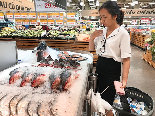 Người tiêu dùng đang lựa chọn cá hồi nhập khẩu tại một siêu thị ở quận Gò Vấp.