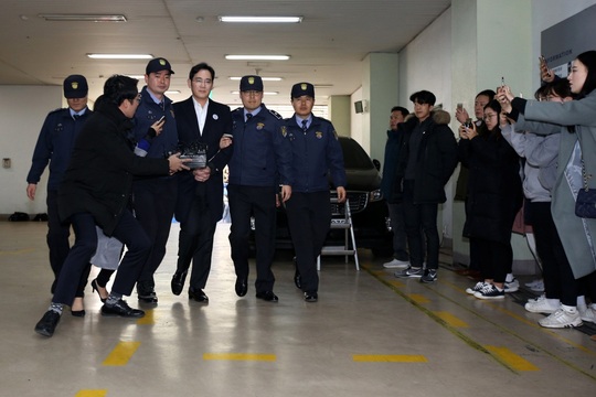 
Ông Lee Jae-yong ở giữa nhân viên cảnh sát ngày 25-2 Ảnh: BLOOMBERG
