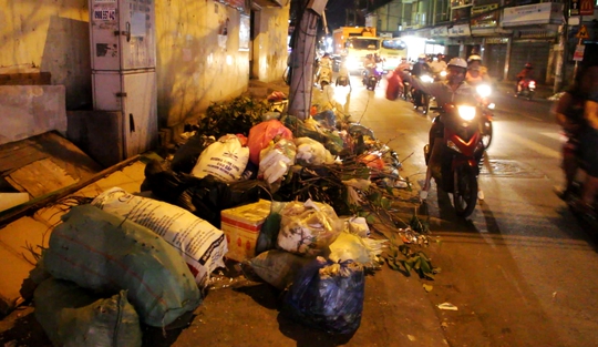 Đường Nguyễn Văn Nghi (quận Gò Vấp) dài hơn 1 km nhưng có cả chục đống rác tự phát (ảnh chụp tại một bãi rác tự phát trên tuyến đường này khoảng 20 giờ ngày 3-5, nhiều người xách từng bọc rác lớn vứt xuống rồi bỏ đi)