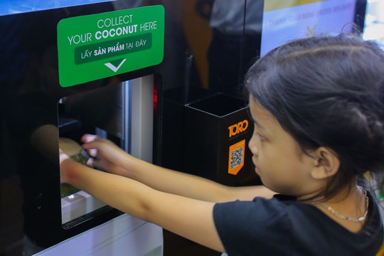 Người Sài Gòn thích thú với máy bán dừa tự động độc đáo - Ảnh 9.