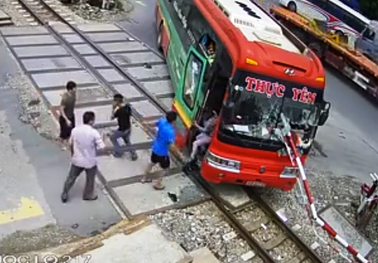 Video: Xe khách tông gãy gác chắn khi tàu hỏa lao tới, hành khách hoảng loạn - Ảnh 2.