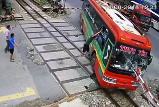 Video: Xe khách tông gãy gác chắn khi tàu hỏa lao tới, hành khách hoảng loạn - Ảnh 3.