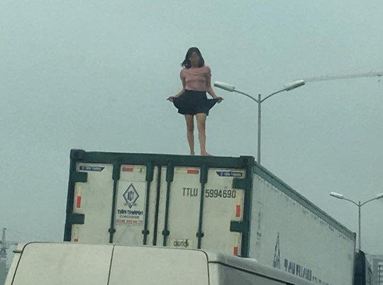 Người phụ nữ mặc váy quậy tưng bừng trên nóc thùng xe container - Ảnh 1.