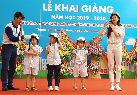 Hoa hậu Lương Thùy Linh trao mũ bảo hiểm cho học sinh trong ngày khai giảng - Ảnh 1.