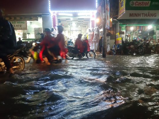 TP HCM: Nước ngập, nhiều người dắt xe trên đường trong mưa lớn - Ảnh 2.