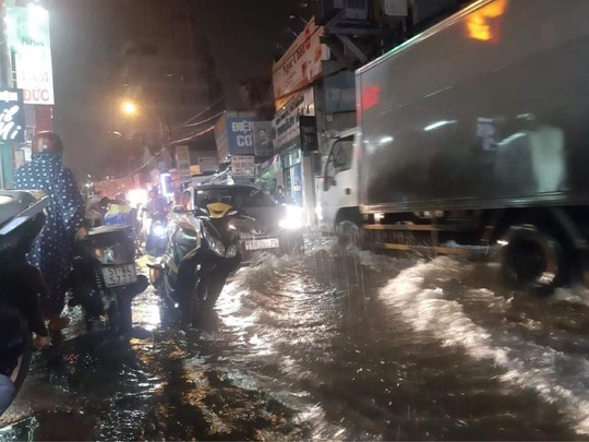 TP HCM: Nước ngập, nhiều người dắt xe trên đường trong mưa lớn - Ảnh 4.