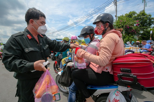 Quân đội, công an tặng thực phẩm, nước uống cho người dân trước khi rời TP HCM về quê - Ảnh 4.